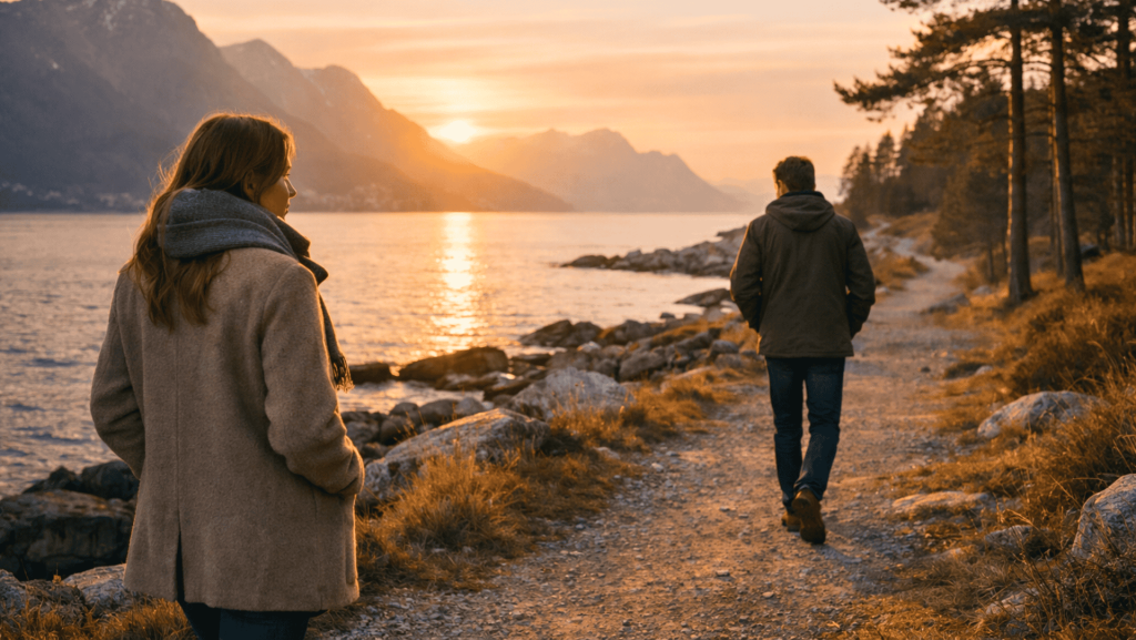 Norsk par som går hver sin vei langs en kyststi ved solnedgang mens de bearbeider kjærlighetssorg symptomer etter et brudd